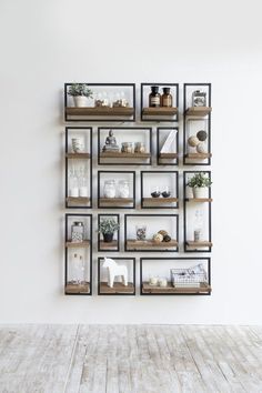 an empty room with some shelves on the wall and plants in vases hanging from them