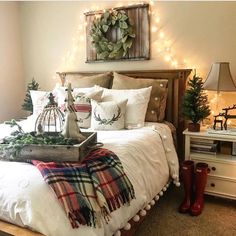 a bedroom decorated for christmas with lights on the wall and bedding in plaid, red and white