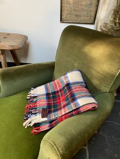 a green chair with a plaid blanket on it