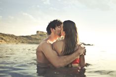 a man and woman kissing in the water