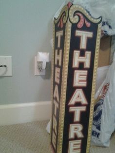 there is a sign that says theatre on the side of the wall in this room