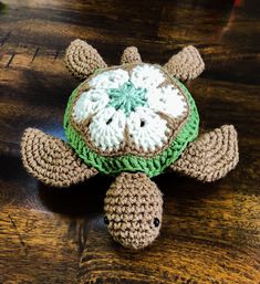 a crocheted turtle sitting on top of a wooden table