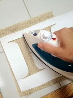 a person ironing fabric with an electric iron on the table next to some scissors