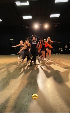 a group of people standing on top of a wooden floor next to each other in an empty room