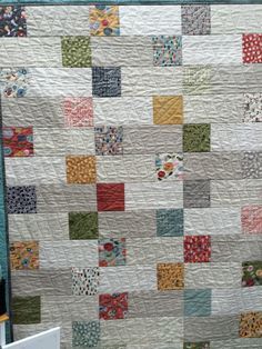 a large quilt is hanging on the wall