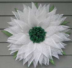 a white and green flower on the side of a building