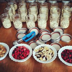 several bowls filled with different types of food on top of a wooden table in front of mason jars