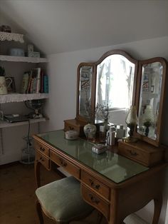 a desk with a mirror and stool in a room