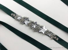 Named after a star in the Sextans constellation, the Bibha bridal belt features star crystals set on handmade silver star sequins, surrounded by encrusted silver hand-beading on a luxurious 15mm forest green satin ribbon, which ties in a bow. Reminiscent of scattered stars in the night sky, the Bibha belt is the perfect nod to a celestial theme. I can create a completely bespoke piece based on this belt. You could even add a personalised monogram to make your piece truly unique. Send me a conversation to start a personalisation request! Beading is roughly 14cm long. All made-to-order pieces are subject to a 4 week lead time - please contact me for rush orders. As each piece is made specially for each bride, I do not usually accept returns. To see my other designs, visit www.etsy.com/uk/sho Hand Beaded Wedding Dress, Celestial Wedding Dress, Star Sequins, Bridesmaid Belt, Bridesmaid Sash, Wedding Dress Sash, Celestial Wedding, Wedding Sash Belt, Dress Sash