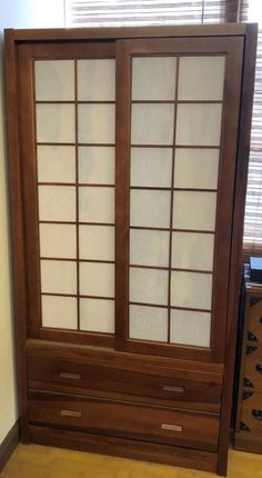 an empty room with a sliding glass door and drawers in the corner, next to a window