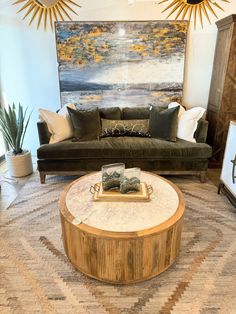 a living room filled with furniture and a large painting on the wall above it's coffee table