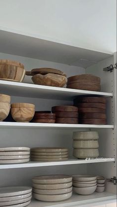 the shelves are filled with bowls and plates