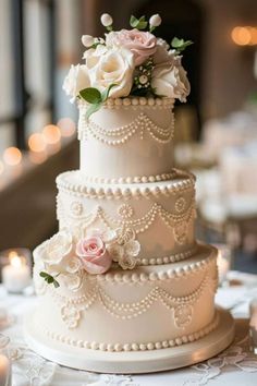 a three tiered wedding cake with white frosting and pink flowers on the top