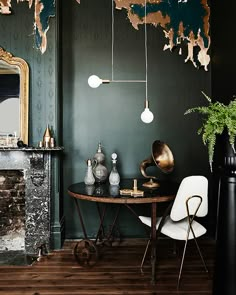 a dining room with green walls and wooden floors, white chairs and a round table in front of a fireplace