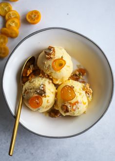 a white bowl filled with oranges and ice cream