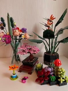 there are many different types of flowers in the vases on the table, and one is made out of legos