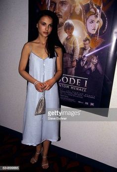 a woman standing in front of a movie poster