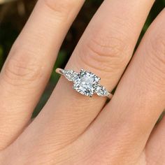 a woman's hand with an engagement ring on it and three stones in the middle