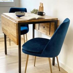 two blue chairs sitting at a wooden table