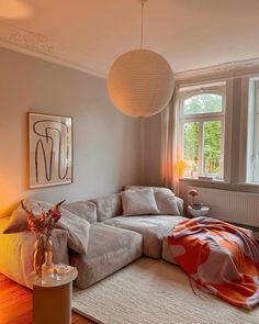 a living room filled with furniture and a large white sectional couch in front of a window