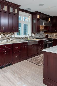 a large kitchen with wooden cabinets and marble counter tops, along with hardwood floorsing