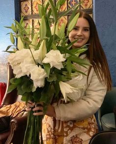 a woman holding a bouquet of white flowers