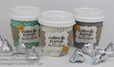 four coffee cups with labels on them are lined up next to some foil wrapped candies