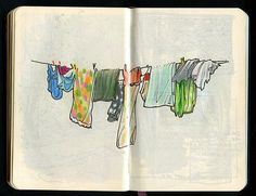 an open book with clothes hanging from the clothesline on it's sides and in between