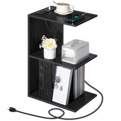 a black book shelf with two shelves on each side and a white flower in the middle