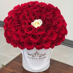 a large bouquet of red roses in a white box