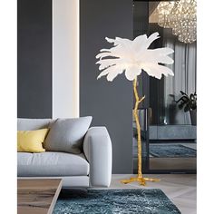 a living room with a couch and a large white flower on the floor next to a mirror