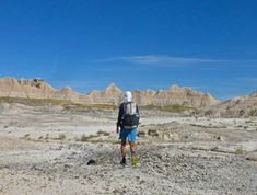 a man with a backpack walking through the desert