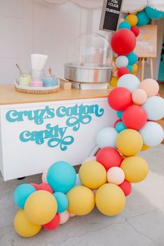 an ice cream stand decorated with balloons and confetti for a baby shower or birthday party