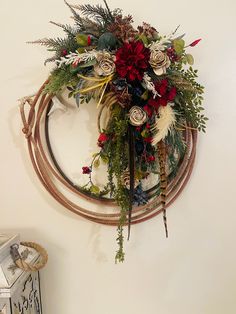 a wreath is hanging on the wall with flowers and feathers around it, along with other decorations