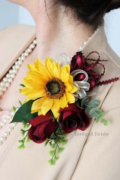 a woman wearing a flower brooch with pearls on her neck and red roses in the center