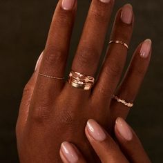 A woman with dark skin and a pristine manicure hand models jewelry. She holds her hands together in front of a black back drop. Each of her fingers is stacked with gold rings. Delicate Rose Gold Flower Ring, Tiny Elegant Flower Ring For Weddings, Delicate Rose Gold Midi Ring With Open Band, Delicate Rose Gold Open Band Midi Rings, Delicate Open Band Midi Ring In Rose Gold, Delicate Stackable Rings With Open Band, Whimsical Gold Wedding Rings, Delicate Tiny Midi Rings For Wedding, Whimsical Rose Gold Jewelry For Wedding