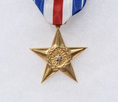 a gold star with a red, white and blue ribbon