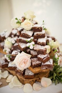 there are many pieces of brownies on the table with flowers and petals around it