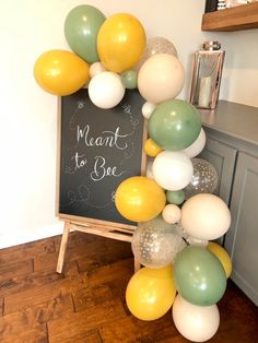 a bunch of balloons that are in front of a chalkboard with the words meant to be written on it