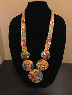 This is a handmade fabric necklace, made with a 70's funky floral fabric. I cut the fabric and wrap it around balsa wood pieces and some padding, sewing it together to make a unique statement necklace! The necklace is a good weight so it will stay put around your neck, and if you're looking for a necklace no one else will have, this is it! Could also make a fun gift for the accessory lovin' lady in your life who has it all! Please note this fabric is from a vintage piece of fabric! Bib Necklaces Statement, Diy Neckpiece, Fabric Jewellery Handmade, Fabric Necklace Diy, Handmade Fabric Jewellery, African Fabric Accessories, Fabric Flower Necklace, Fabric Bangles, Diy Fabric Jewellery