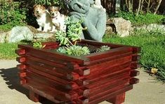 two dogs are sitting next to a wooden planter