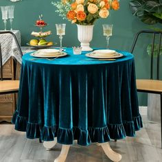 the table is set for two with plates and glasses on it, along with flowers in a vase