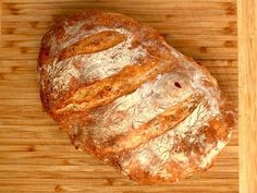 a loaf of bread sitting on top of a wooden cutting board