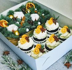 a box filled with cupcakes covered in frosting and orange zesty decorations