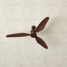 a brown ceiling fan on a white wall