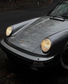 a grey sports car parked on the side of the road