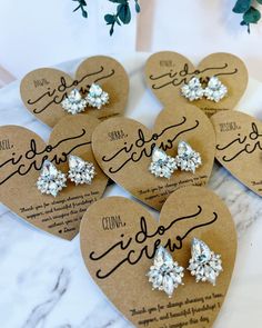 six heart shaped tags with bows on them sitting on top of a marble countertop