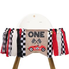 a wooden chair with a race car banner on it's back and ribbon around the seat