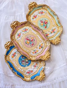 three decorative plates sitting on top of a white cloth