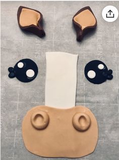 a cookie shaped like a face with two eyes and one nose on top of a piece of paper